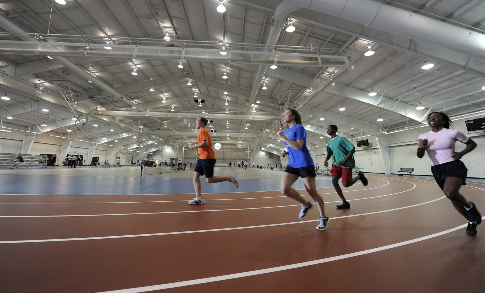 A group of students running on the indoor track