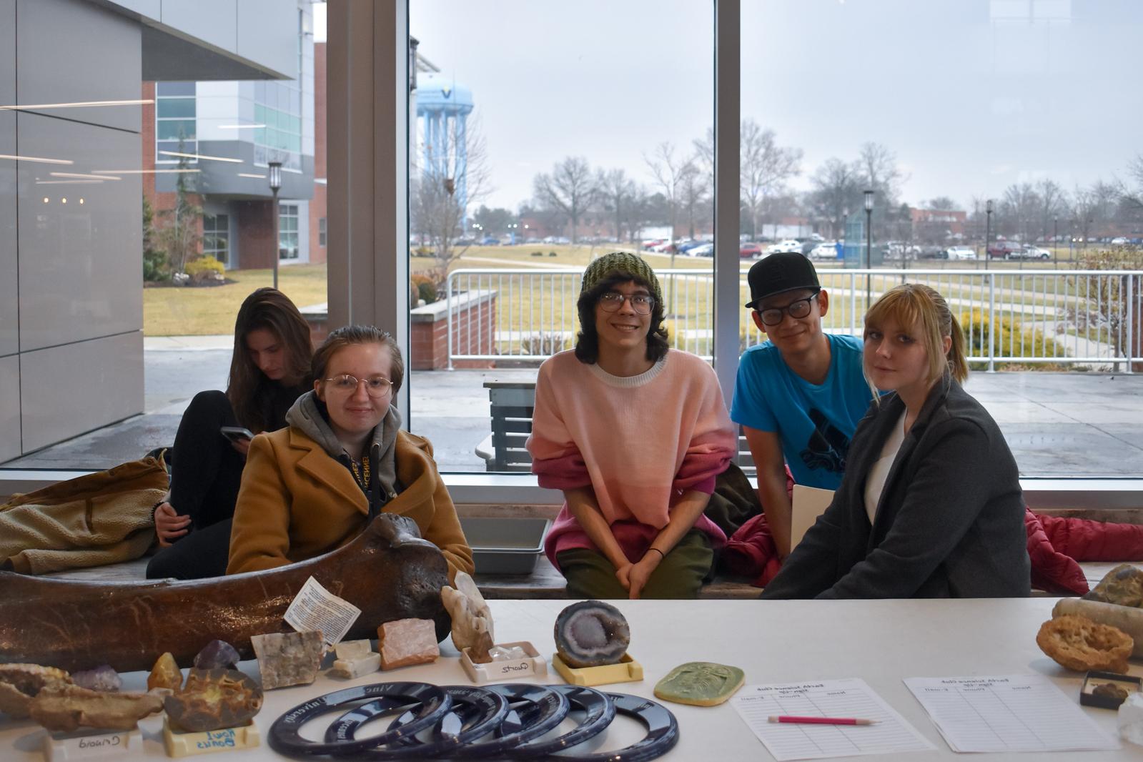 A group of students in Jefferson Student Union sitting at a table with minerals and a giant bone